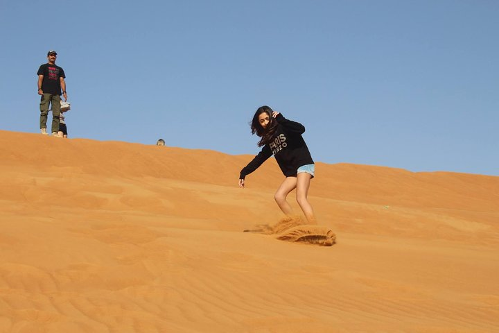 Experience the joy of gliding down the golden dunes as you embrace the spirit of adventure in the Arabian desert where sandboarding adds excitement to your desert safari journey.